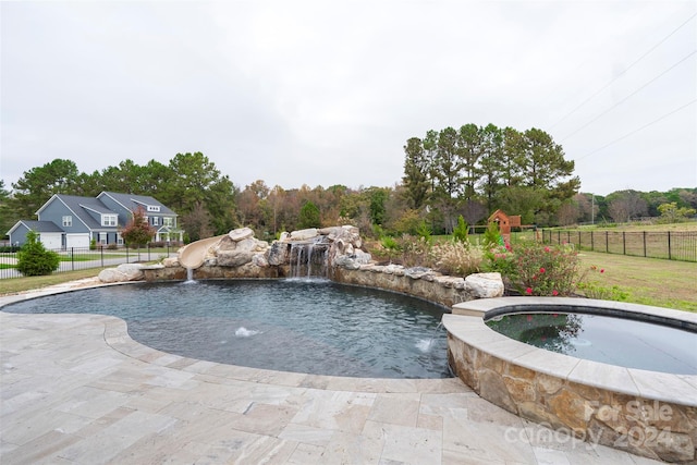 view of pool featuring a patio, pool water feature, and an in ground hot tub