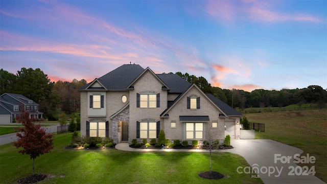 french provincial home with a lawn and a garage