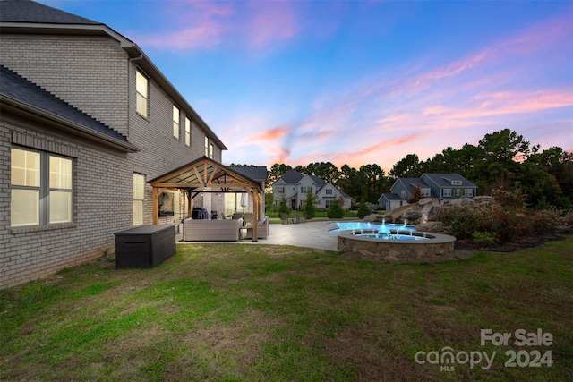 yard at dusk with a gazebo, outdoor lounge area, and a patio area