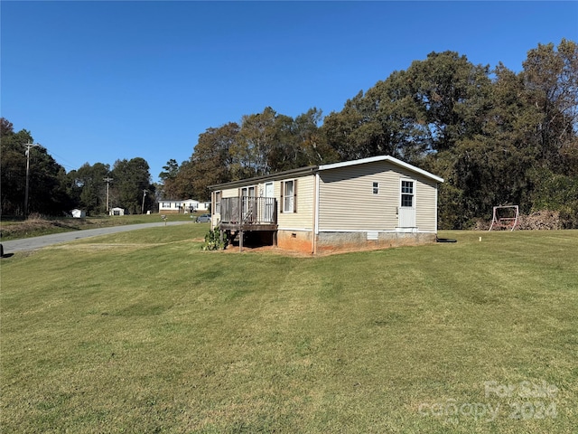 view of side of property with a deck and a yard