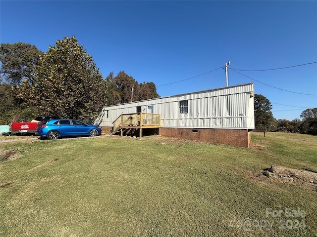 view of front of property with a front yard and a wooden deck