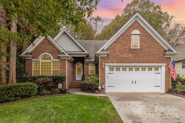 front of property with a garage and a yard