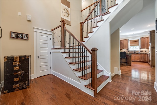 stairs with sink and hardwood / wood-style floors