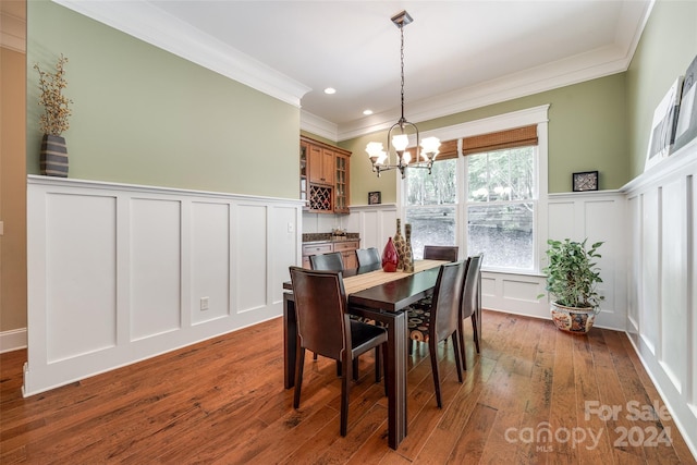 dining room with crown molding, dark hardwood / wood-style flooring, and an inviting chandelier