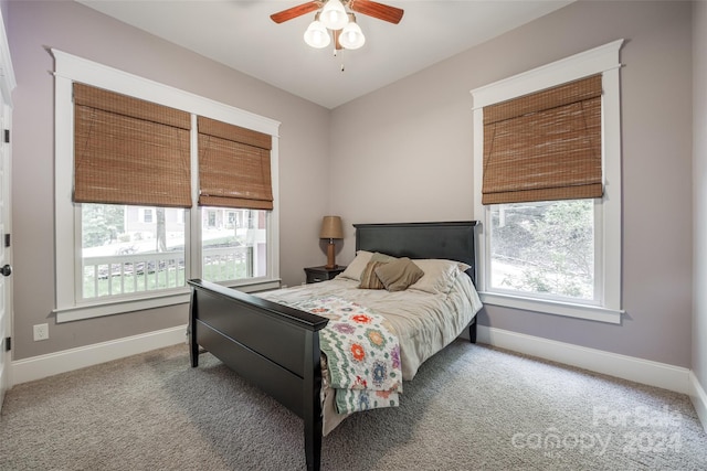 carpeted bedroom with multiple windows and ceiling fan