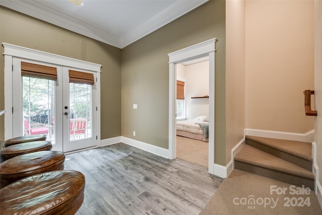 doorway to outside with french doors, ornamental molding, and light hardwood / wood-style flooring