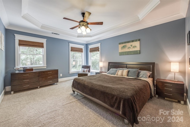 bedroom featuring ceiling fan, light carpet, a tray ceiling, and crown molding