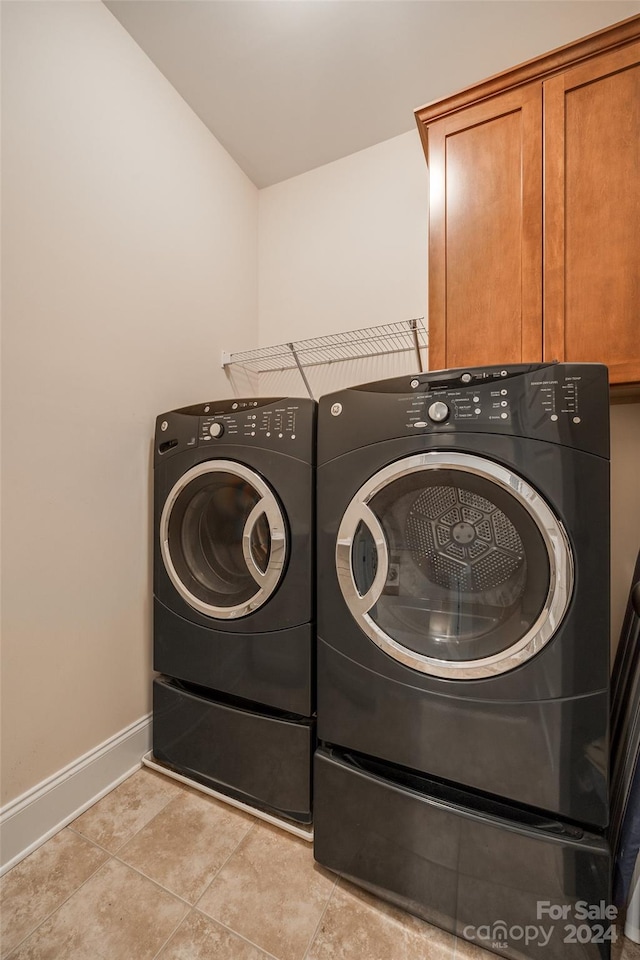 washroom featuring cabinets, independent washer and dryer, and light tile patterned flooring