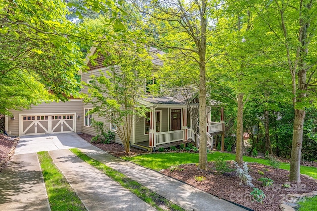 view of front of home featuring covered porch, a garage, and a front lawn