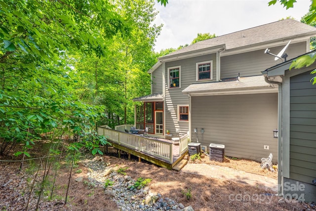 rear view of property featuring a wooden deck