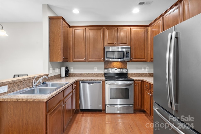 kitchen featuring sink, stainless steel appliances, and light hardwood / wood-style floors