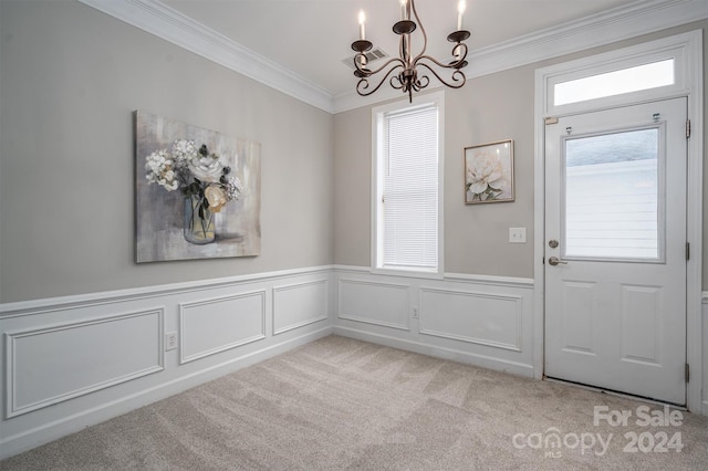 carpeted foyer entrance featuring ornamental molding and an inviting chandelier