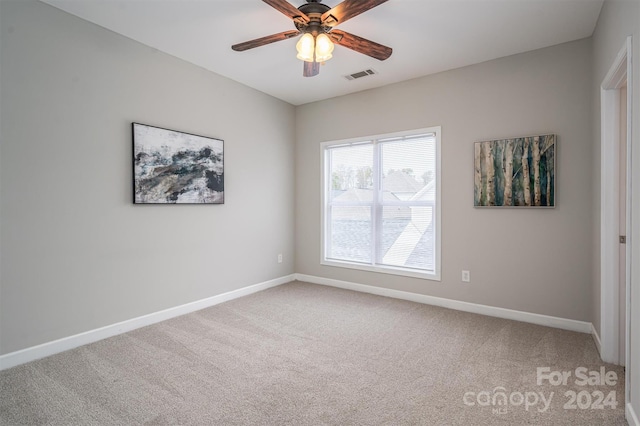 carpeted spare room with ceiling fan