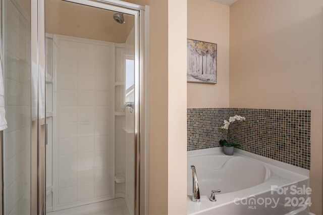 bathroom featuring shower with separate bathtub