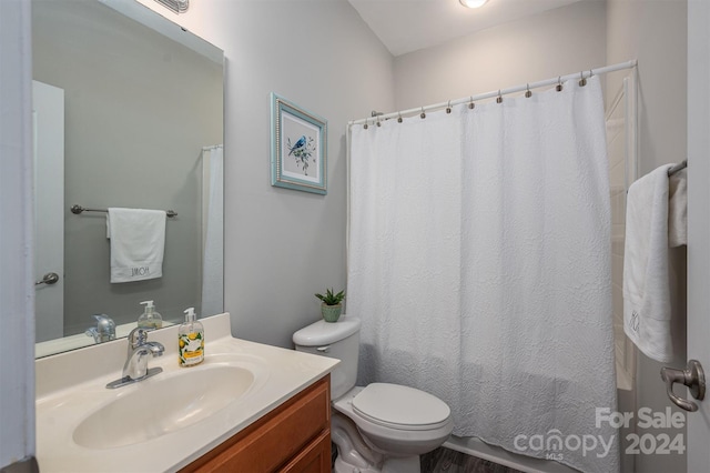 bathroom featuring vanity, toilet, and walk in shower