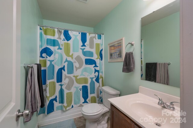 full bathroom featuring vanity, shower / bath combo with shower curtain, and toilet