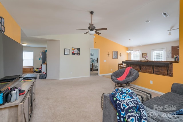 living room featuring lofted ceiling, light carpet, and ceiling fan with notable chandelier