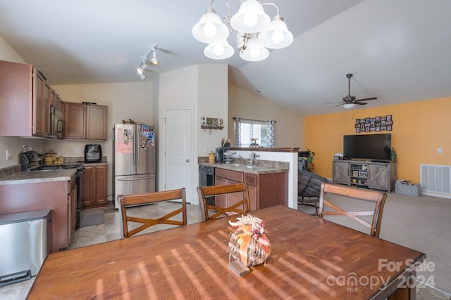 carpeted dining area with sink, track lighting, vaulted ceiling, and ceiling fan with notable chandelier