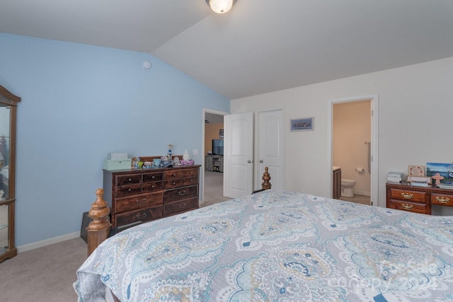 bedroom featuring ensuite bathroom, vaulted ceiling, and light colored carpet