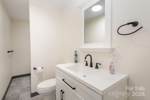 bathroom with vanity, toilet, and tile patterned floors