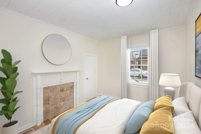 bedroom with ornamental molding and hardwood / wood-style flooring