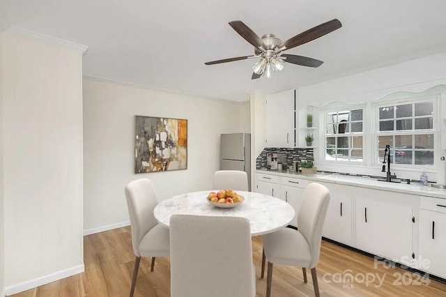 dining room with ornamental molding, sink, light hardwood / wood-style floors, and ceiling fan