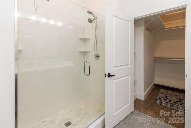 55 S Market St Unit 512, Asheville, NC 28801 - full bath featuring a shower stall, a spacious closet, baseboards, and wood finished floors