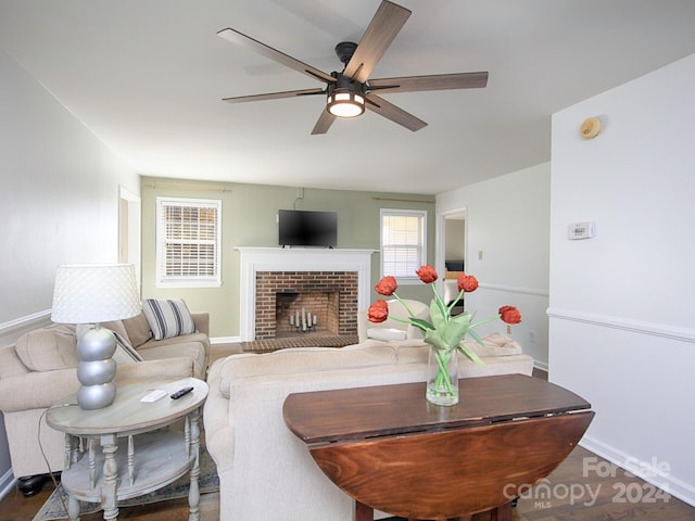 living room with a brick fireplace, hardwood / wood-style floors, and ceiling fan