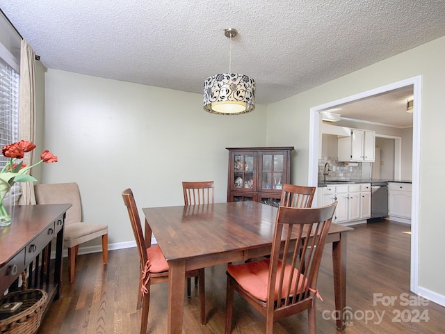 dining room with a textured ceiling, dark wood-type flooring, and sink