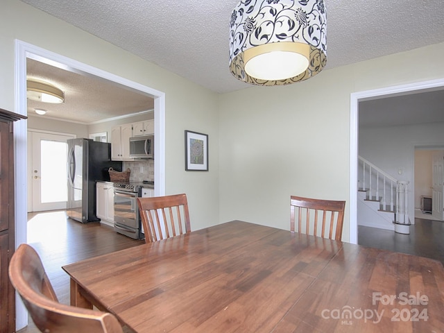 dining room with dark hardwood / wood-style flooring and a textured ceiling