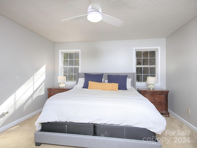 carpeted bedroom with a textured ceiling and ceiling fan