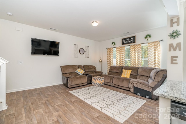 living area with light wood finished floors, baseboards, and visible vents