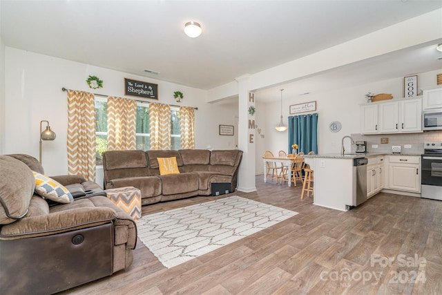 living room with dark wood-type flooring and ornate columns