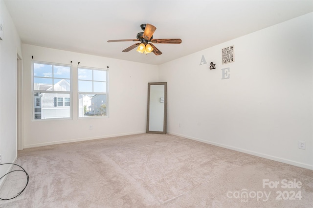 empty room with ceiling fan and light carpet