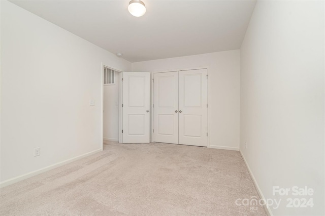 unfurnished bedroom featuring a closet, visible vents, baseboards, and carpet floors