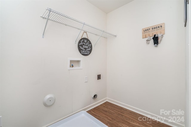 clothes washing area featuring wood finished floors, laundry area, hookup for an electric dryer, hookup for a washing machine, and baseboards