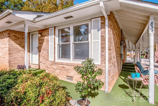 doorway to property with a lawn