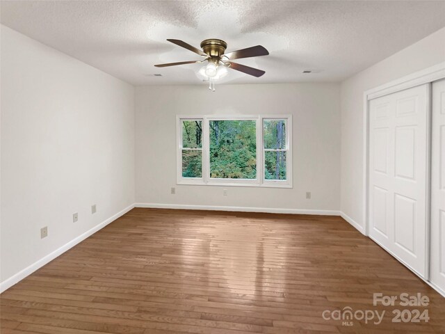 1259 Blacksnake Rd, Stanley, NC 28164 - unfurnished bedroom featuring hardwood / wood-style floors, baseboards, a textured ceiling, a closet, and ceiling fan