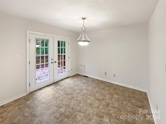 1259 Blacksnake Rd, Stanley, NC 28164 - unfurnished dining area featuring french doors, baseboards, and a textured ceiling
