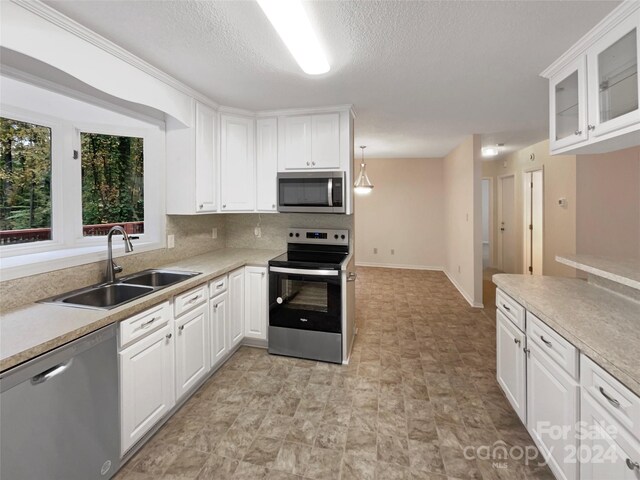 1259 Blacksnake Rd, Stanley, NC 28164 - kitchen featuring appliances with stainless steel finishes, a sink, white cabinetry, light countertops, and a textured ceiling