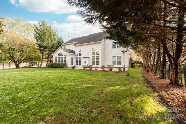 rear view of property with a yard