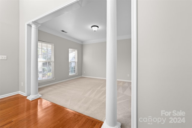 spare room with ornamental molding, ornate columns, and wood-type flooring