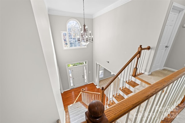 foyer featuring light hardwood / wood-style floors, an inviting chandelier, and crown molding