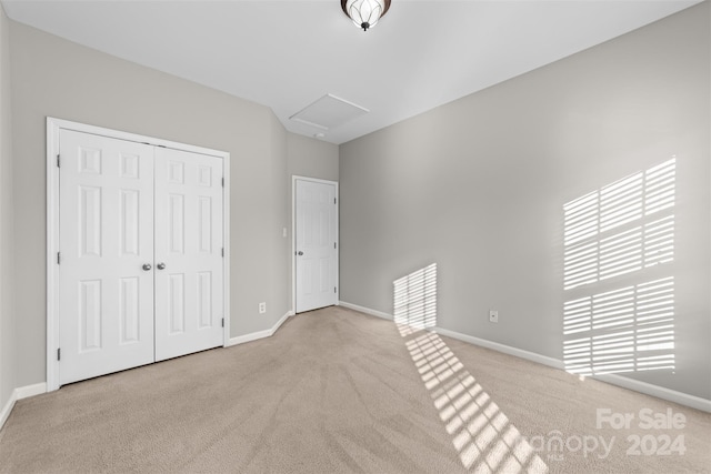 unfurnished bedroom featuring a closet, multiple windows, and light colored carpet