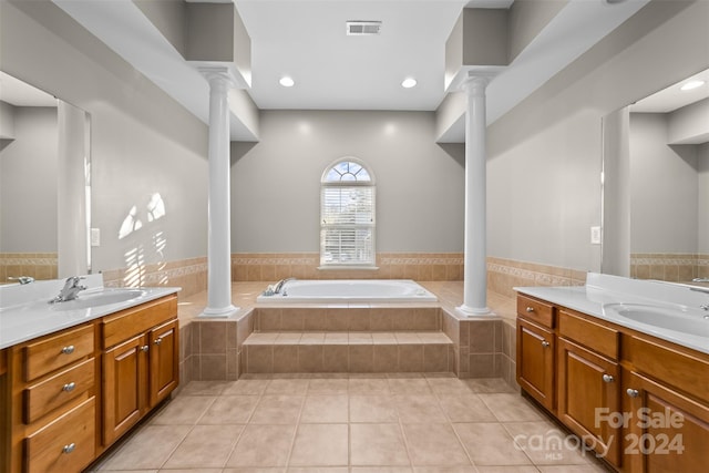 bathroom featuring vanity, tiled tub, and tile patterned flooring