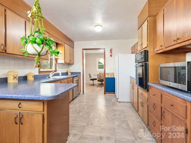 kitchen with decorative backsplash, sink, and appliances with stainless steel finishes