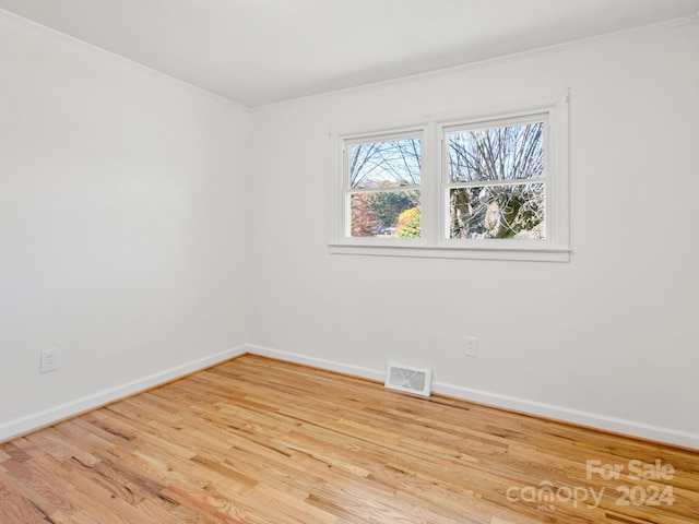 unfurnished room featuring light wood-type flooring and crown molding