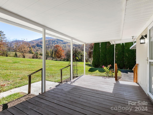 deck with a mountain view and a yard