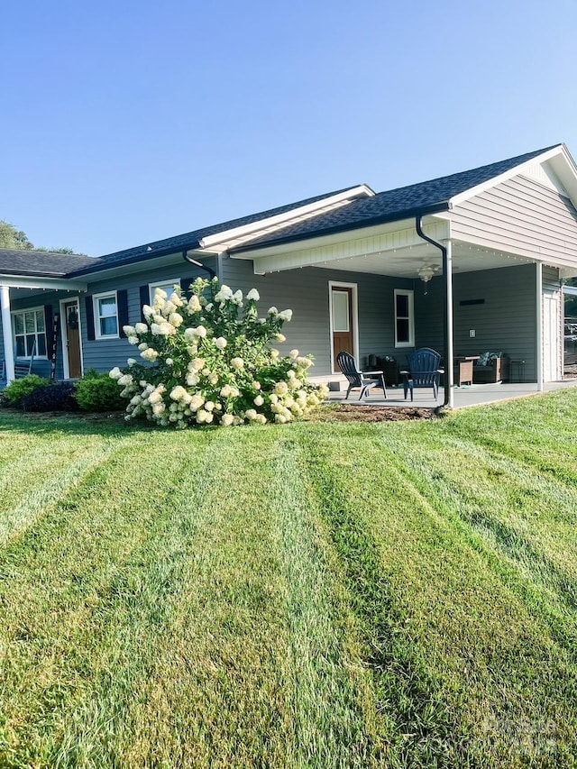 rear view of house with a yard and a patio