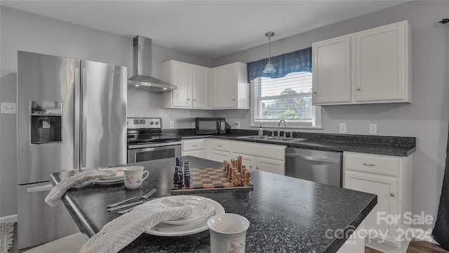 kitchen featuring white cabinets, appliances with stainless steel finishes, sink, and wall chimney range hood